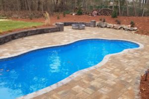 Swimming pool with decorative retaining wall and fire pit