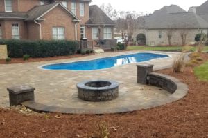 Swimming Pool with hardscape and fire pit with decorative retaining wall
